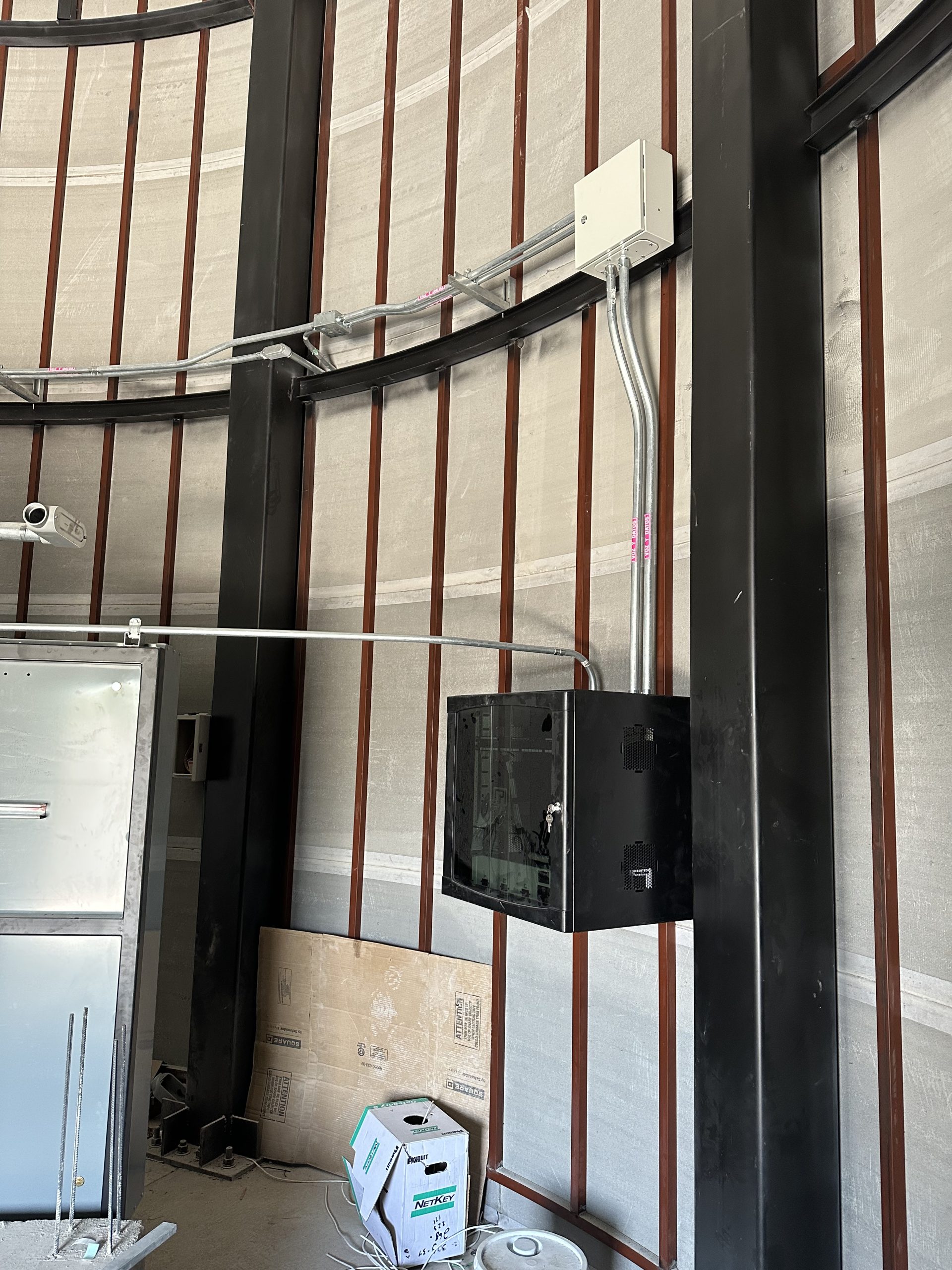 Montaje de rack de telecomunicaciones de pared industrial con canalización conduit metálica